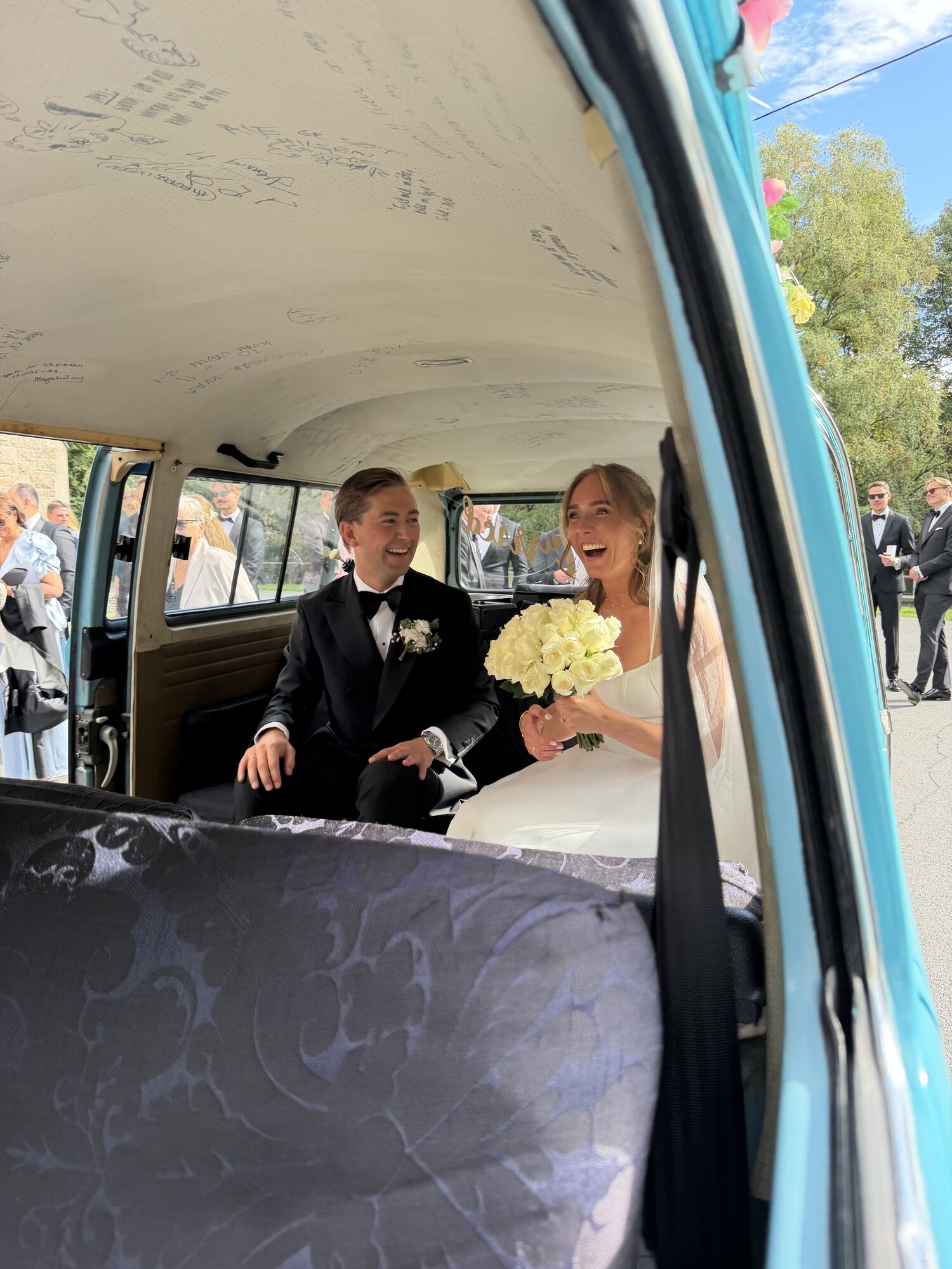 Brudepar sitter smilende i den turkise VW-bussen utenfor Fagerborg kirke i Oslo